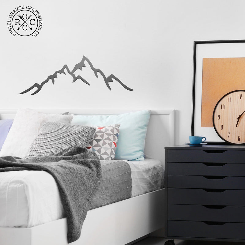 mountain metal wall art on wall above bed