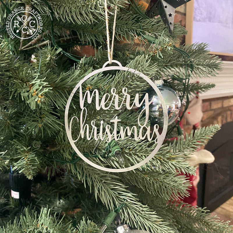 merry christmas ornament hanging on christmas tree