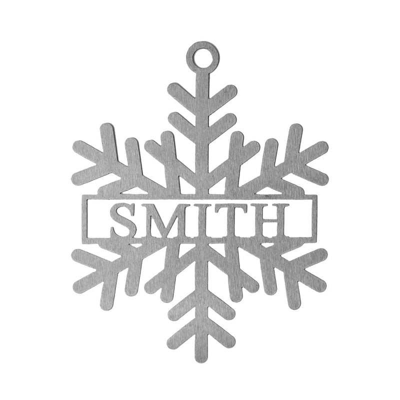 Metal snowflake with last name in center shown against white background.