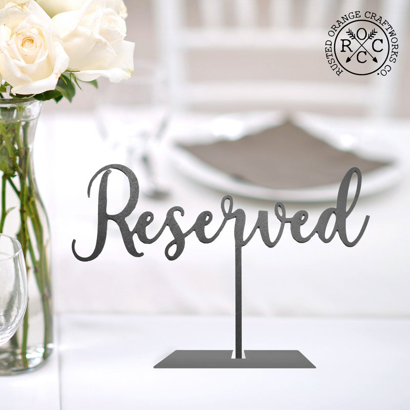 reserved sign on table by flowers