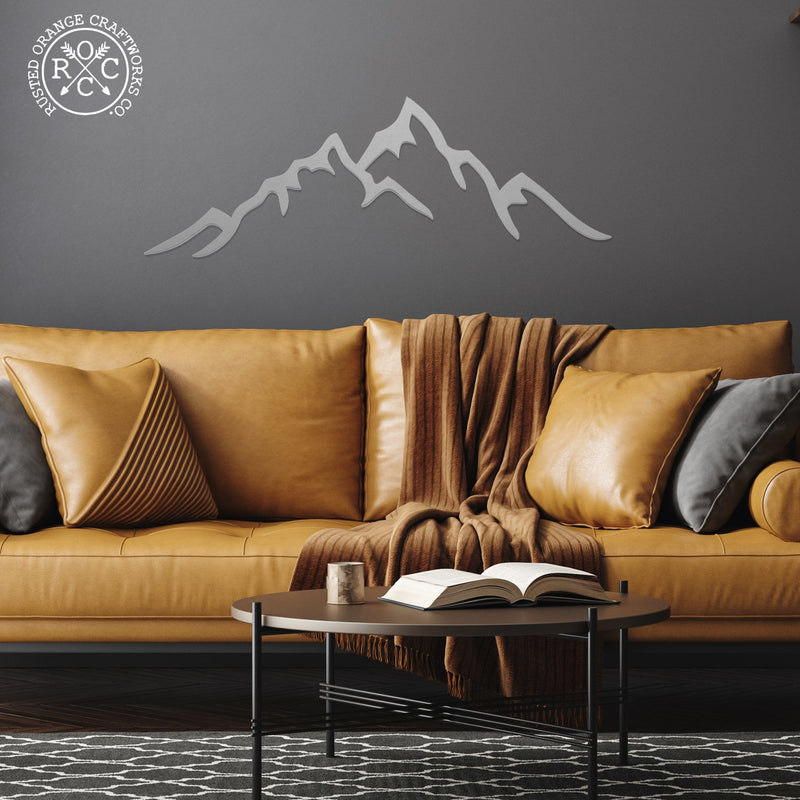 mountain metal wall art on wall above couch