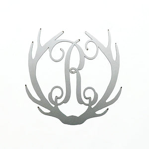 Metal deer antlers with monogram R in the middle, shown against white background.