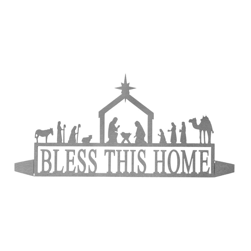 Metal sign saying bless this home below nativity scene silhouette, shown against white background.