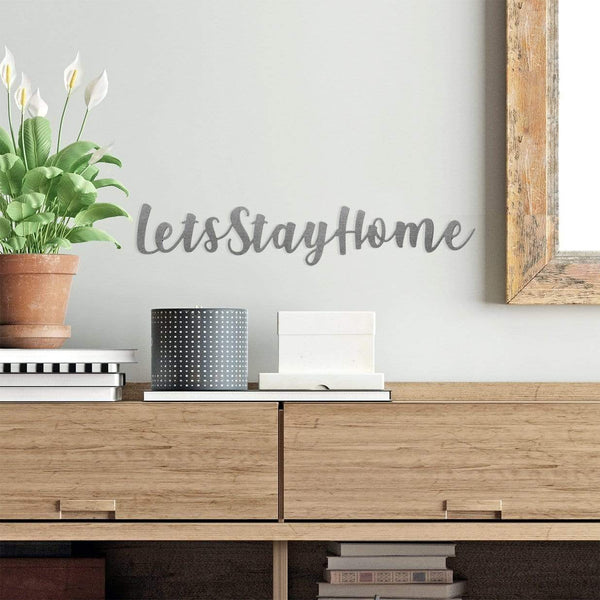 lets stay home phrase sign on wall