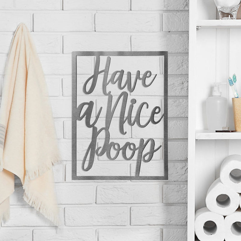 Metal rectangle humorous bathroom phrase sign hanging on bathroom wall next to shelf.