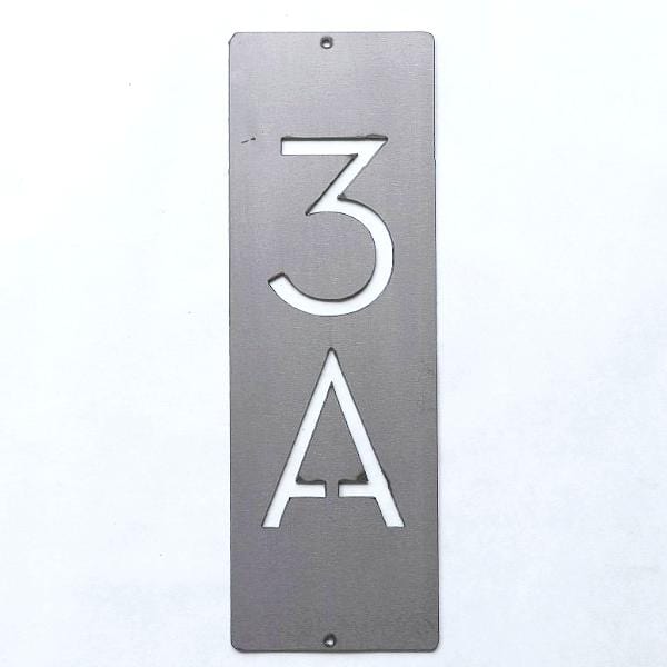 Metal vertical house number against white background.