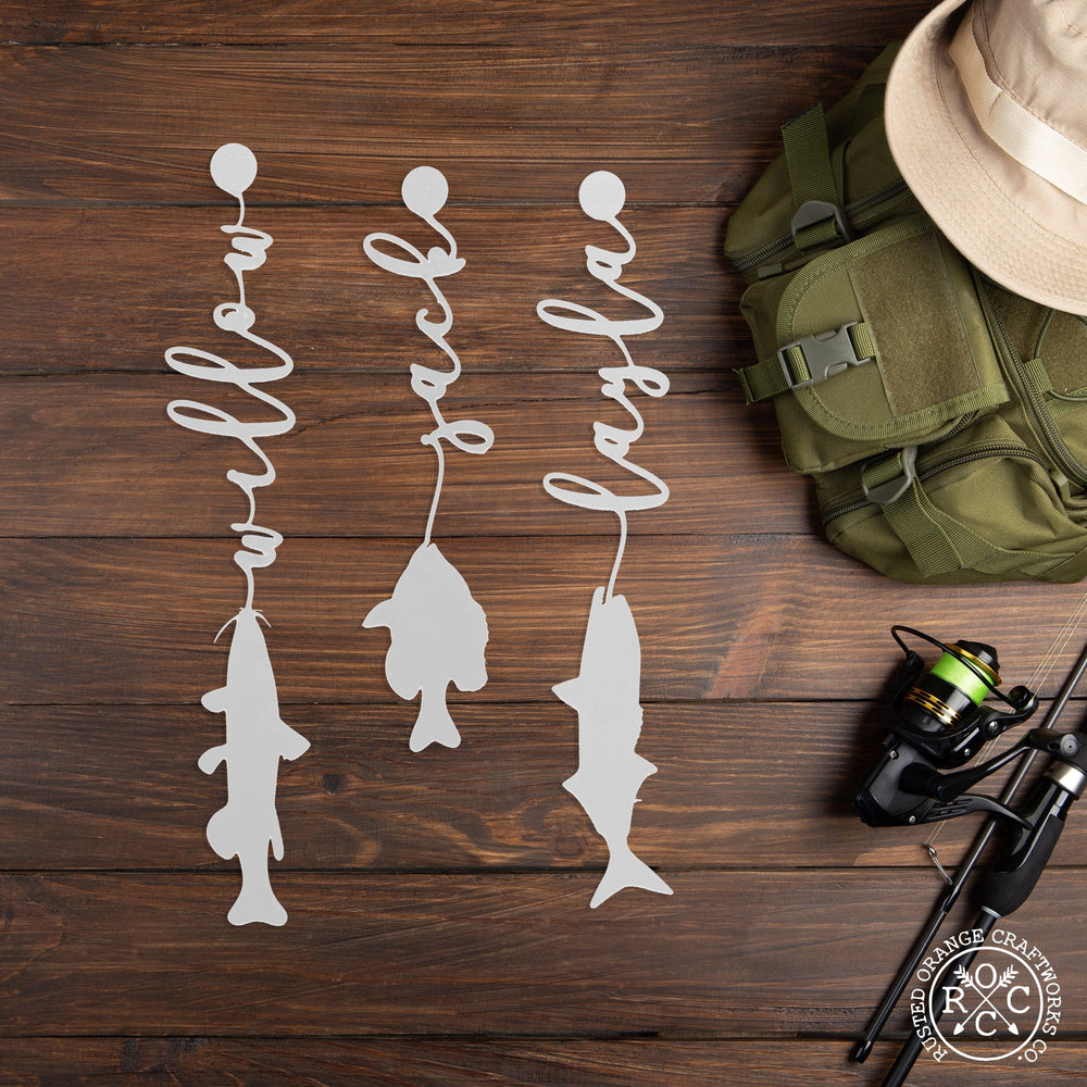 3 fish with names on the table next to fishing gear