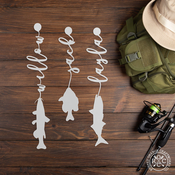 3 fish with names on the table next to fishing gear