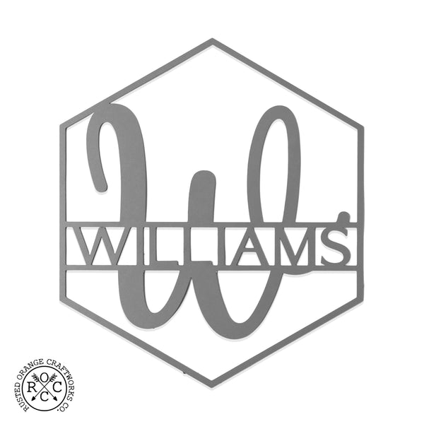 Hexagon shaped metal sign with last name and monogram in center, shown against white background.