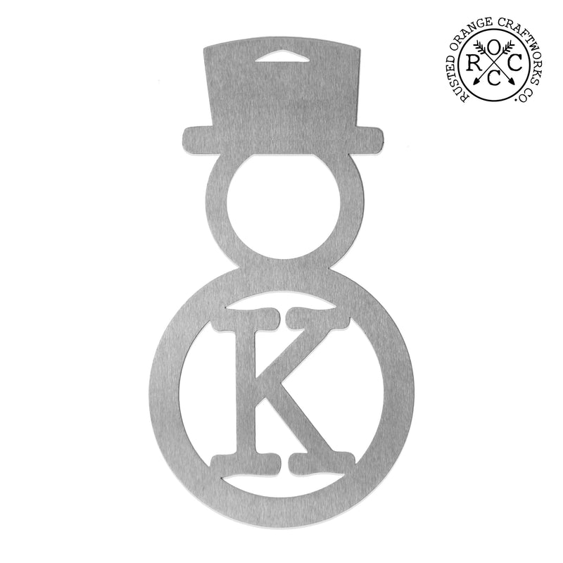Metal snowman shaped ornament with monogram shown against white background.