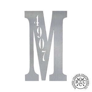 Metal letter with house number inscribed, against white background.