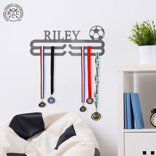 Medal holder on wall above soccer styled bean bag