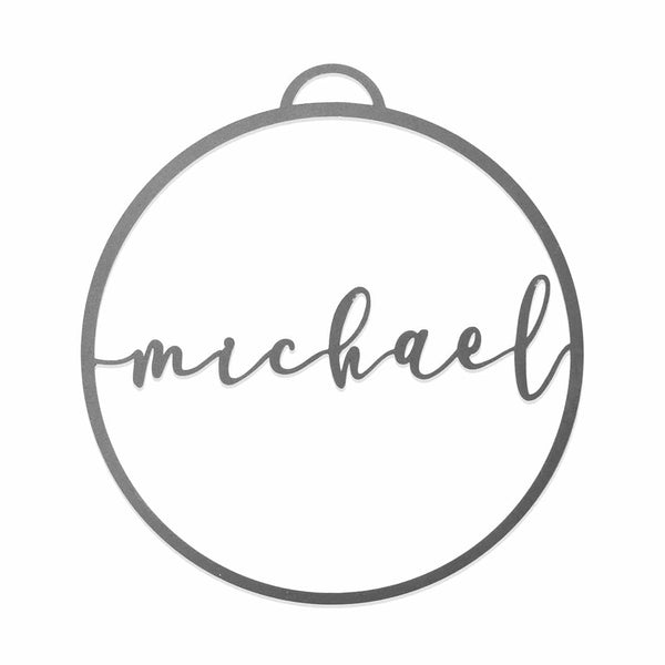 Circle metal ornament with name across center shown against white background.