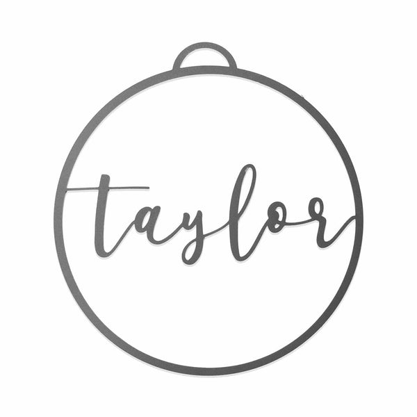 Circle metal ornament with name across center shown against white background.