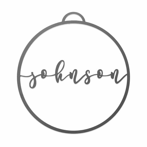 Circle metal ornament with name across center shown against white background.