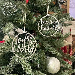 joy to the world and merry christmas ornaments hanging on christmas tree