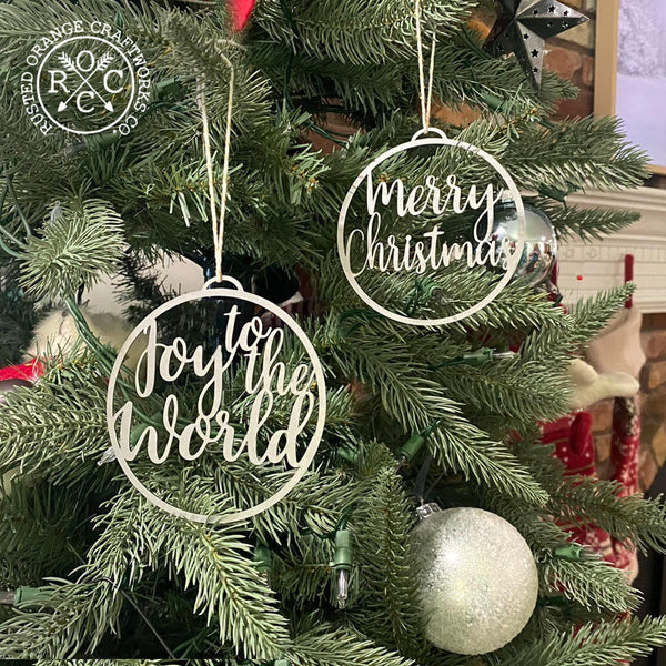 joy to the world and merry christmas ornaments hanging on christmas tree