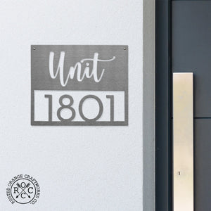 address plaque on wall next to front door
