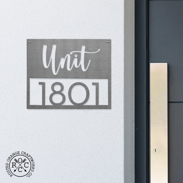 address plaque on wall next to front door