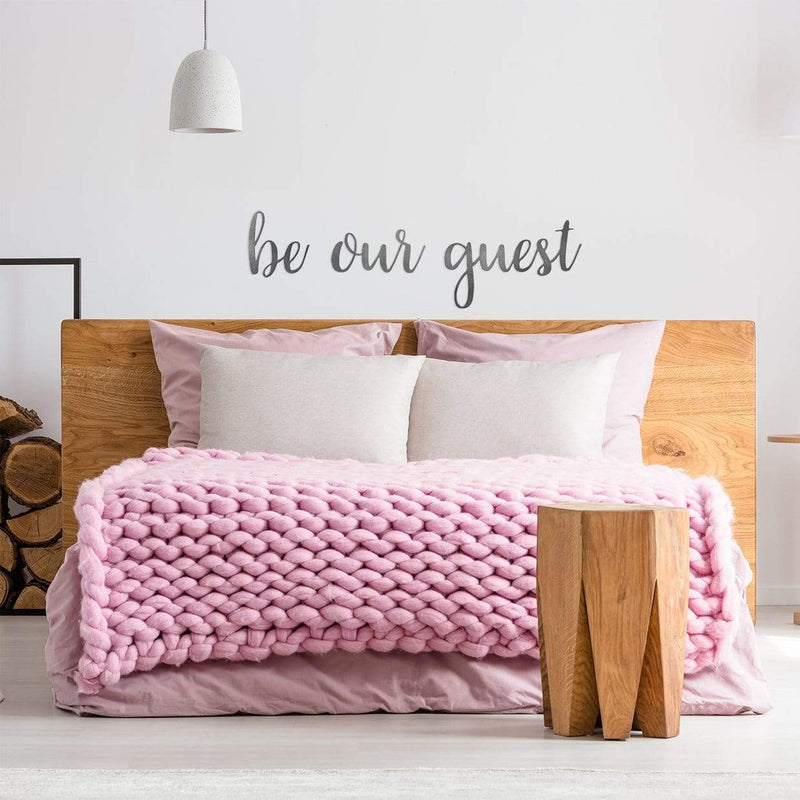 be out guest sign on wall above bed