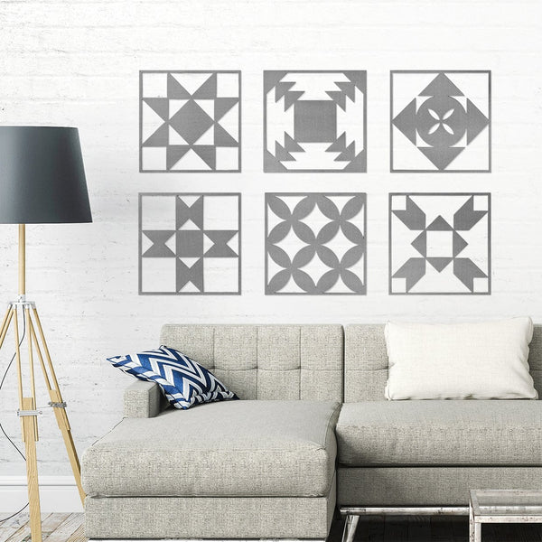 Six metal quilt block design squares hanging on wall above couch. 