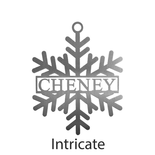 Metal snowflake with last name in center shown against white background.