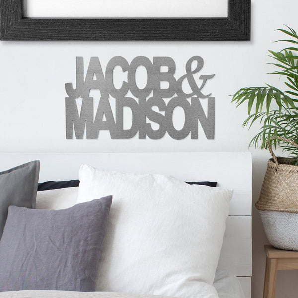 Metal sign of names Jacob & Madison hanging on wall above couch.