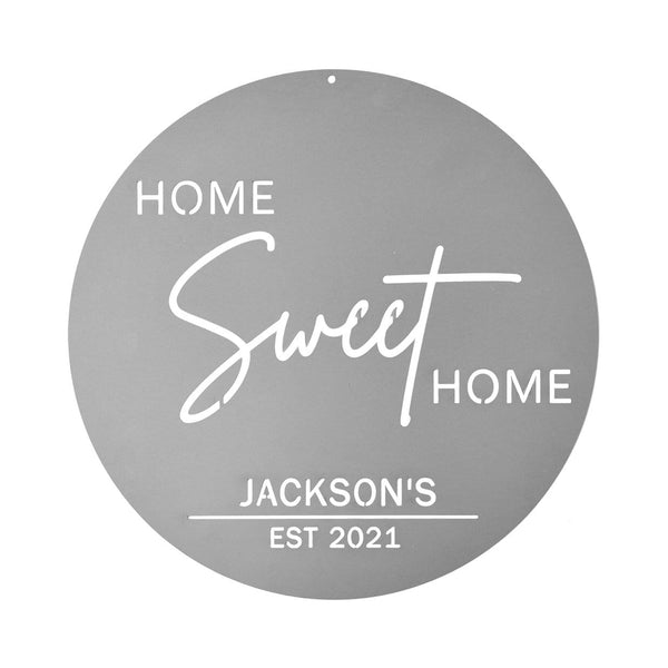 Circle metal sign saying home sweet home with family name, shown against white background.
