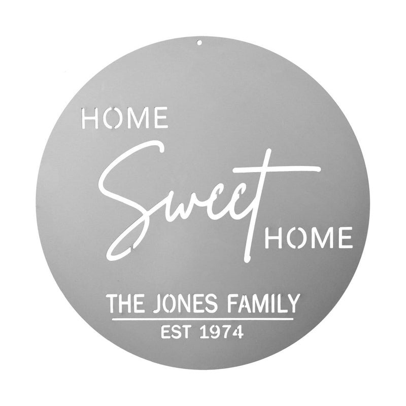 Circle metal sign saying home sweet home with family name, shown against white background.