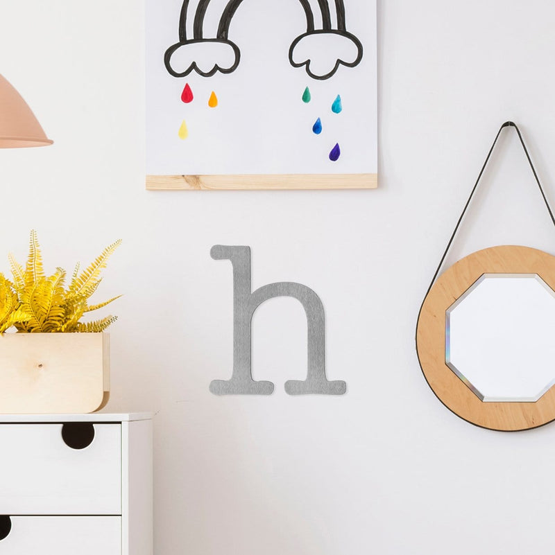 Letter H metal decoration hanging on wall in child's bedroom.