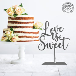 love is sweet sign on table next to wedding cake
