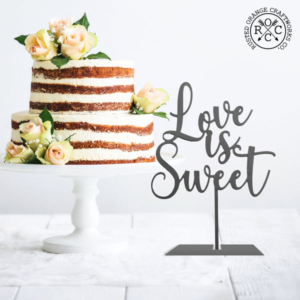 love is sweet sign on table next to wedding cake