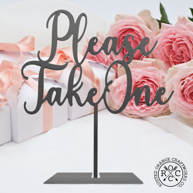 please take on sign on table by wedding favor and flowers