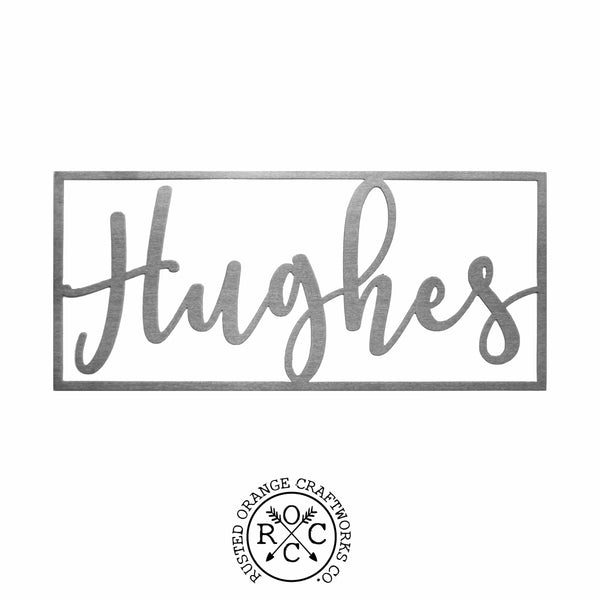 Metal cursive family name sign within rectangle against white background.