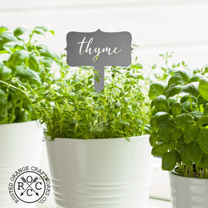 Thyme metal herb identification stake in white potted plant.