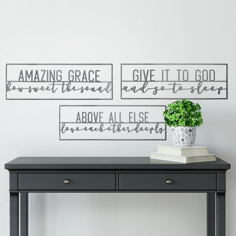 3 metal rectangle inspirational signs hanging on wall above table.